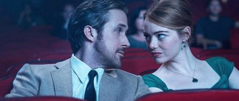 Sebastian and Mia looking into each other's eyes in a movie theater in La La Land